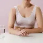 Woman in White Tank Top Sitting at the White Table